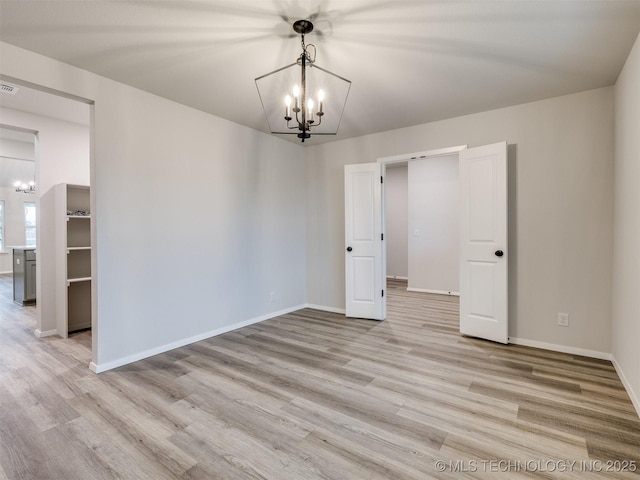 13406 E 124th St, Collinsville, OK 74021 - empty room featuring baseboards, light wood-style floors, and a chandelier