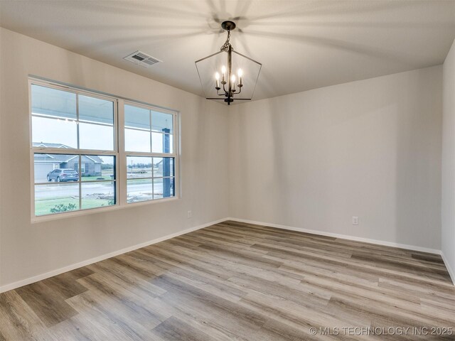 13406 E 124th St, Collinsville, OK 74021 - unfurnished room featuring an inviting chandelier, wood finished floors, baseboards, and visible vents