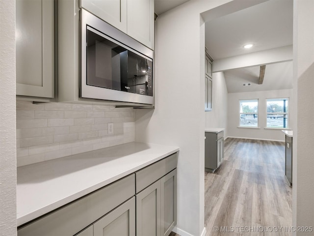 13406 E 124th St, Collinsville, OK 74021 - kitchen featuring gray cabinets, tasteful backsplash, light countertops, and stainless steel microwave
