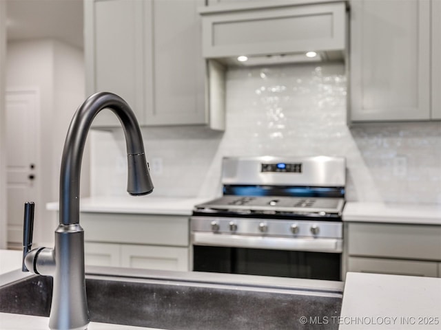 13406 E 124th St, Collinsville, OK 74021 - kitchen featuring exhaust hood, light countertops, stainless steel gas stove, and decorative backsplash