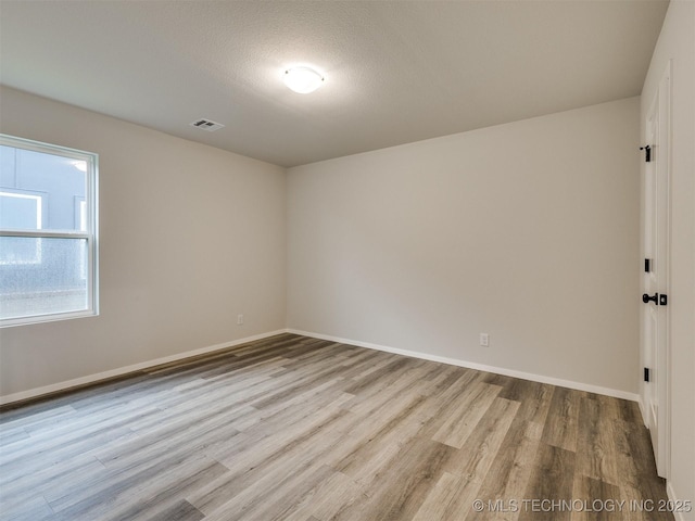 13406 E 124th St, Collinsville, OK 74021 - spare room with baseboards, visible vents, and wood finished floors