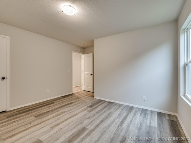 13406 E 124th St, Collinsville, OK 74021 - empty room featuring baseboards, wood finished floors, and a textured ceiling