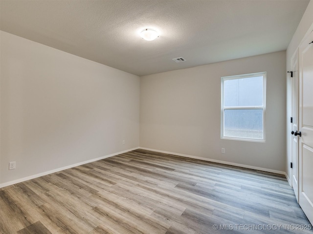 13406 E 124th St, Collinsville, OK 74021 - unfurnished room featuring wood finished floors, a textured ceiling, baseboards, and visible vents