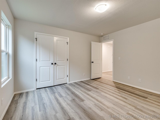 13406 E 124th St, Collinsville, OK 74021 - unfurnished bedroom with light wood finished floors, baseboards, visible vents, and a closet