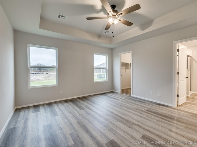 13406 E 124th St, Collinsville, OK 74021 - unfurnished bedroom with a raised ceiling, baseboards, light wood-style flooring, and visible vents