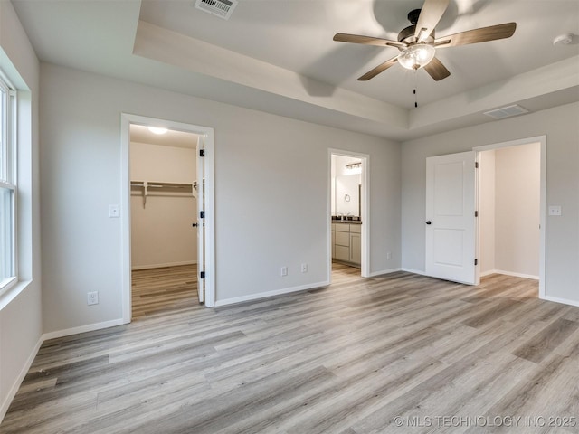 13406 E 124th St, Collinsville, OK 74021 - unfurnished bedroom with a raised ceiling, visible vents, baseboards, and light wood-type flooring