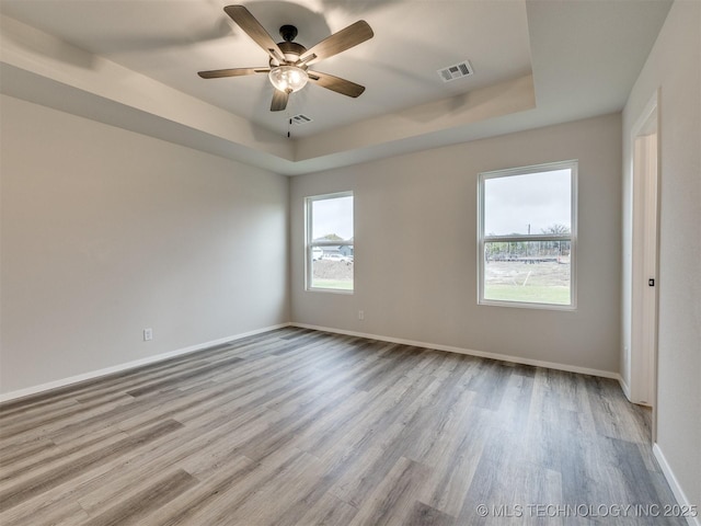 13406 E 124th St, Collinsville, OK 74021 - empty room with a raised ceiling, wood finished floors, baseboards, and visible vents