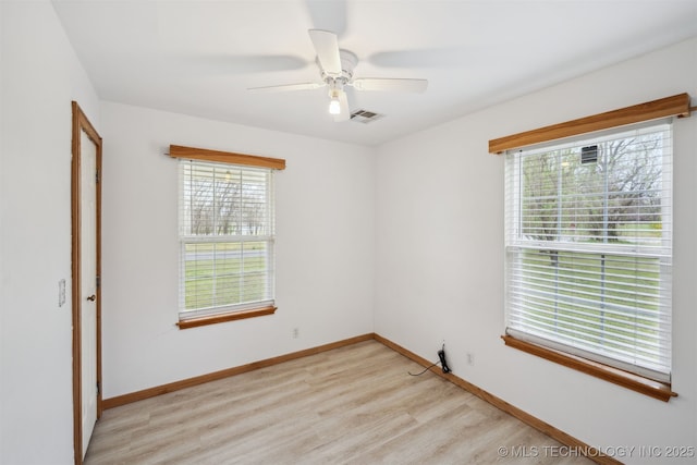 unfurnished room featuring baseboards, visible vents, light wood-style floors, and ceiling fan