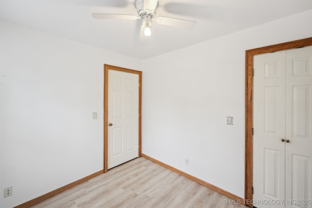 unfurnished bedroom featuring a ceiling fan, light wood-style floors, baseboards, and a closet