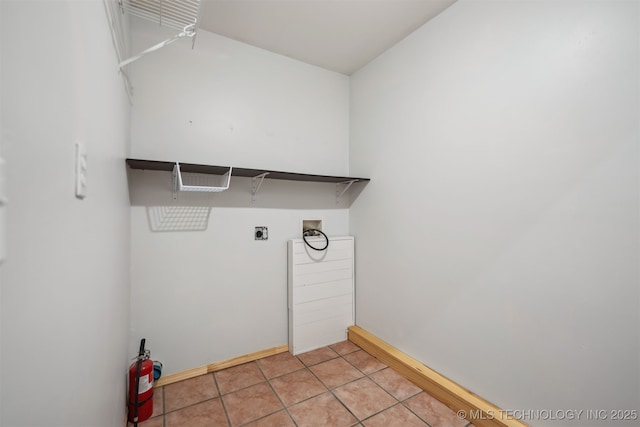 laundry room with hookup for a washing machine, baseboards, light tile patterned flooring, electric dryer hookup, and laundry area