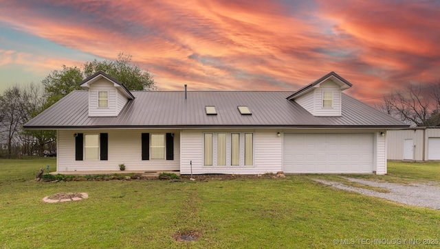 view of front of home featuring driveway, covered porch, metal roof, a lawn, and a garage