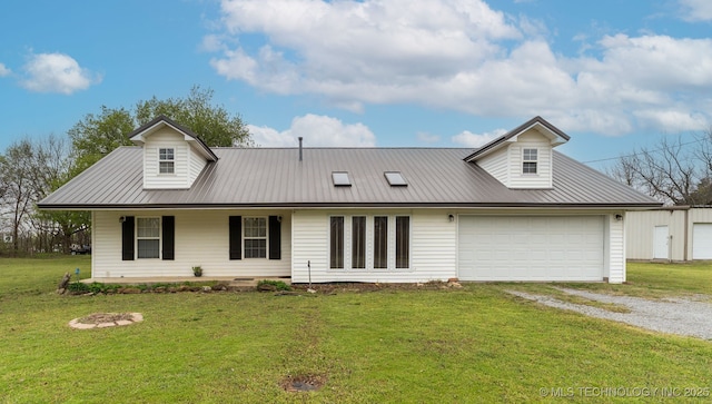 view of front facade featuring metal roof, an attached garage, driveway, a front lawn, and covered porch