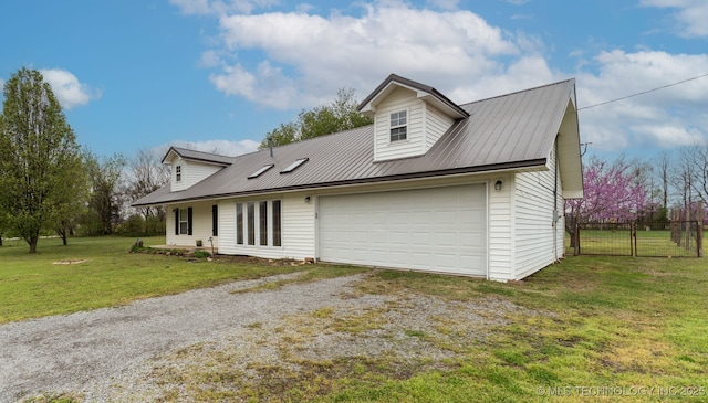 exterior space with gravel driveway, metal roof, fence, and a front lawn