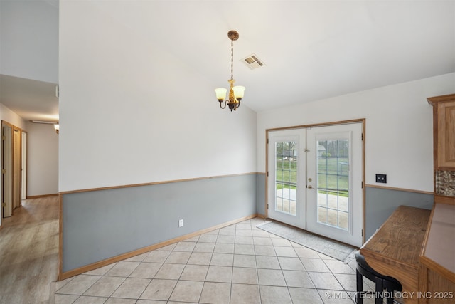 unfurnished dining area with visible vents, an inviting chandelier, lofted ceiling, french doors, and light tile patterned floors