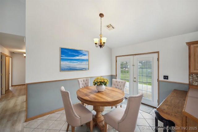 dining area featuring visible vents, lofted ceiling, light tile patterned floors, and a chandelier