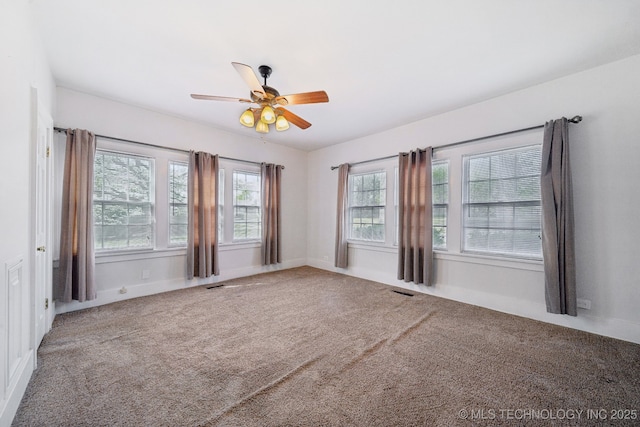 carpeted spare room with a ceiling fan