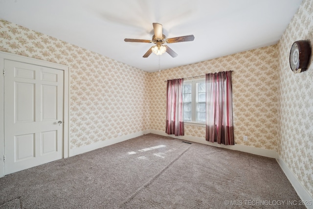 empty room featuring baseboards, ceiling fan, wallpapered walls, and carpet