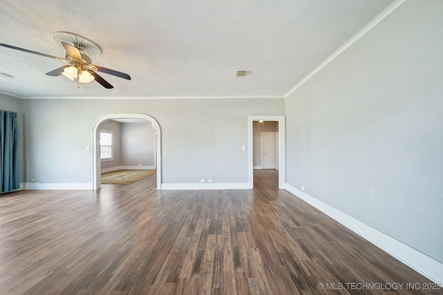 spare room featuring a ceiling fan, arched walkways, baseboards, and wood finished floors