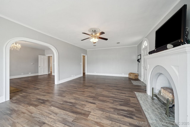 unfurnished living room featuring baseboards, wood finished floors, arched walkways, and ceiling fan