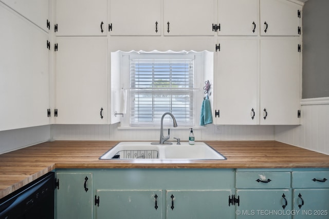 kitchen featuring black dishwasher, white cabinetry, and a sink
