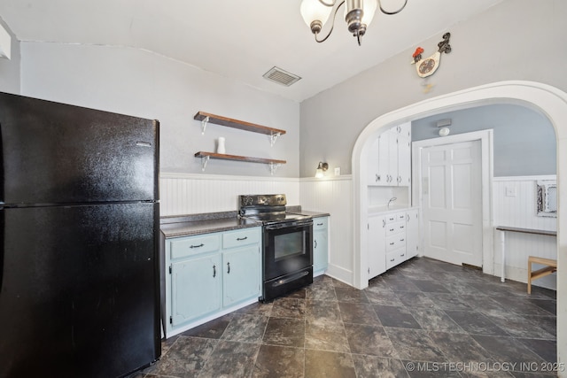 kitchen featuring visible vents, black appliances, dark countertops, and wainscoting