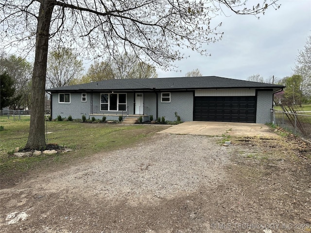 ranch-style house featuring fence, brick siding, dirt driveway, and an attached garage