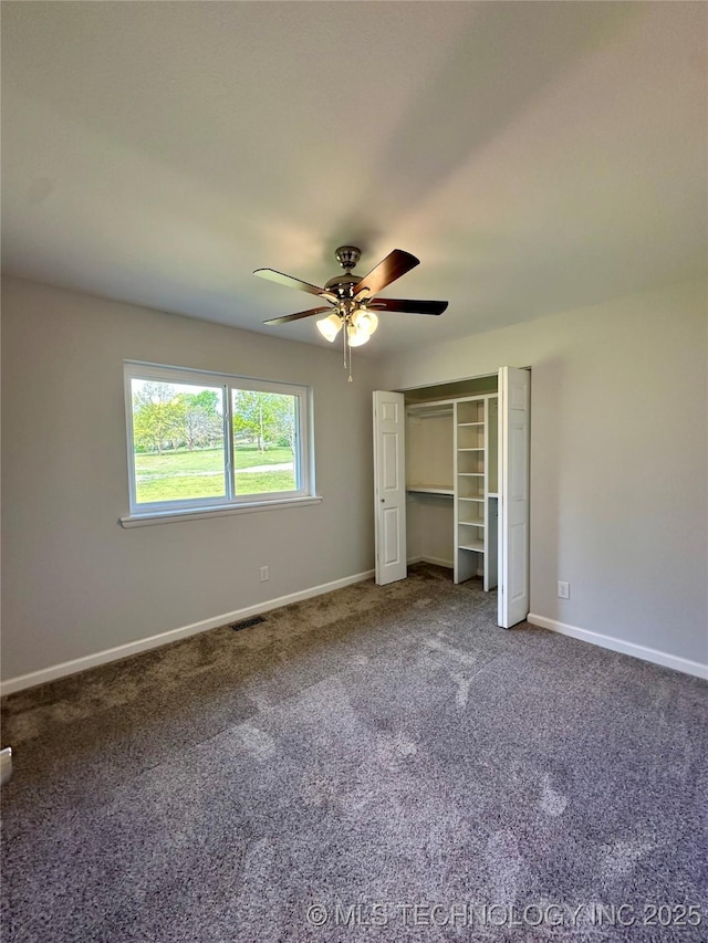 unfurnished bedroom featuring baseboards, a ceiling fan, carpet floors, and a closet