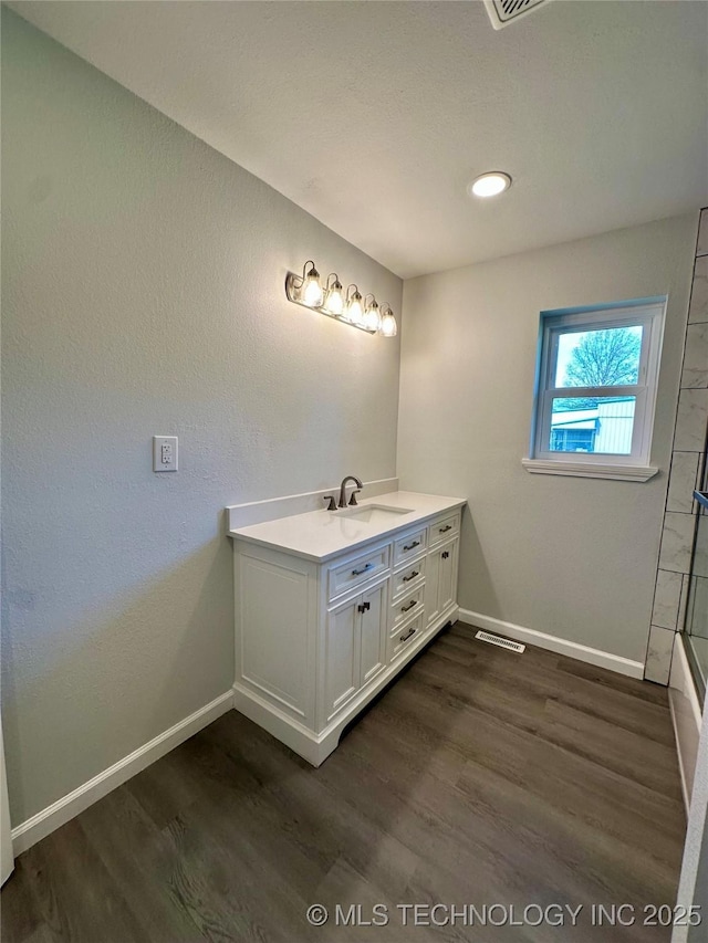 full bath featuring recessed lighting, wood finished floors, vanity, baseboards, and visible vents