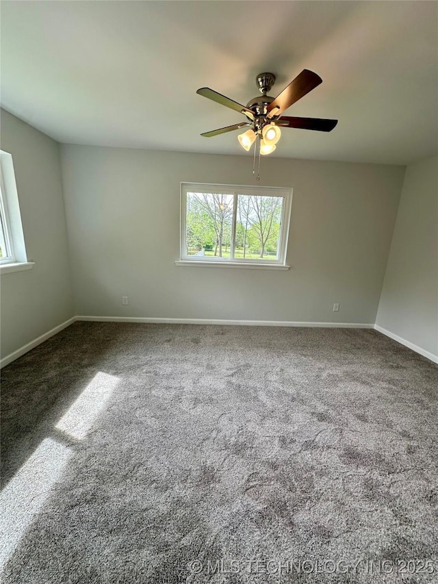 empty room with carpet, a ceiling fan, and baseboards