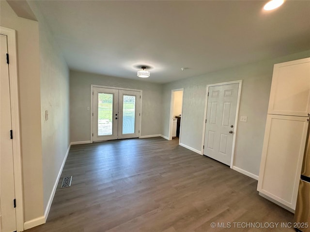 interior space featuring wood finished floors, french doors, visible vents, and baseboards