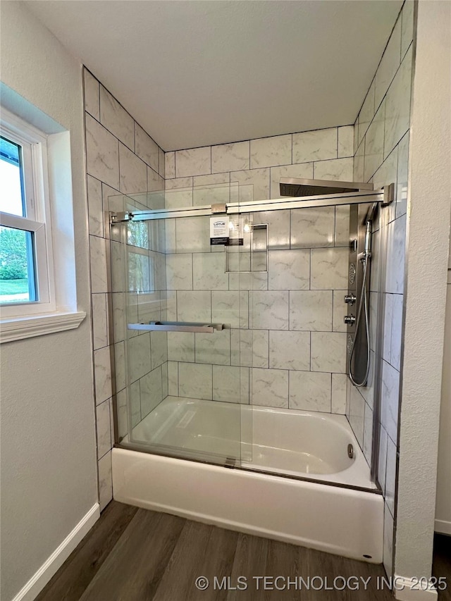 bathroom featuring bath / shower combo with glass door, wood finished floors, and baseboards