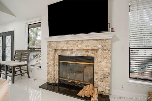 interior details featuring baseboards, visible vents, and a glass covered fireplace