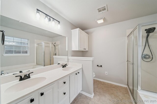 bathroom with visible vents, a sink, a stall shower, and toilet