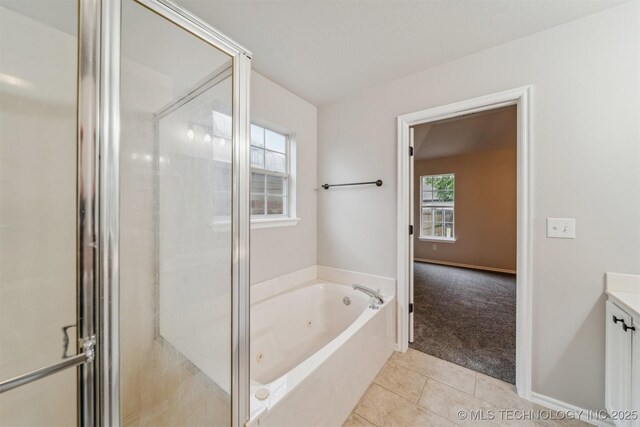 bathroom with a whirlpool tub, vanity, tile patterned floors, and a shower stall
