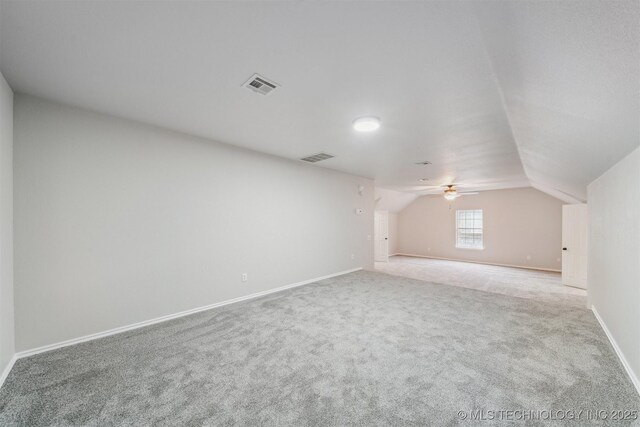 additional living space featuring ceiling fan, visible vents, vaulted ceiling, baseboards, and carpet