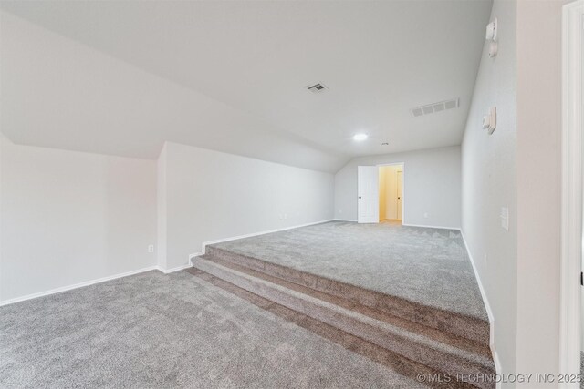 bonus room with carpet floors, visible vents, and vaulted ceiling