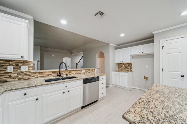 kitchen featuring stainless steel dishwasher, visible vents, arched walkways, tasteful backsplash, and a sink