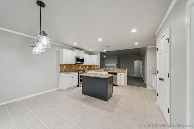 kitchen with arched walkways, a center island, stainless steel appliances, a peninsula, and ornamental molding