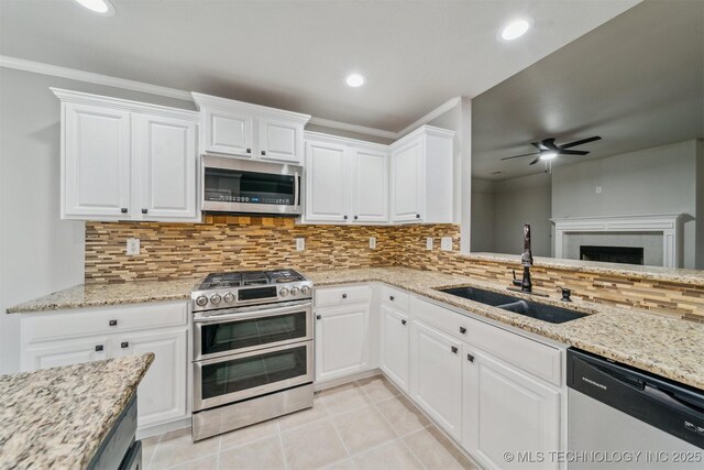 kitchen featuring ceiling fan, appliances with stainless steel finishes, decorative backsplash, and a sink