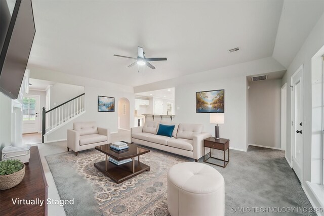 living room featuring baseboards, a ceiling fan, stairs, and visible vents