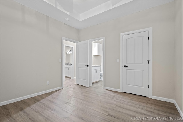 809 H NW, Ardmore, OK 73401 - unfurnished bedroom with ensuite bathroom and light wood-style flooring