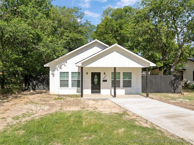 809 H NW, Ardmore, OK 73401 - view of front of house featuring covered porch, concrete driveway, and board and batten siding