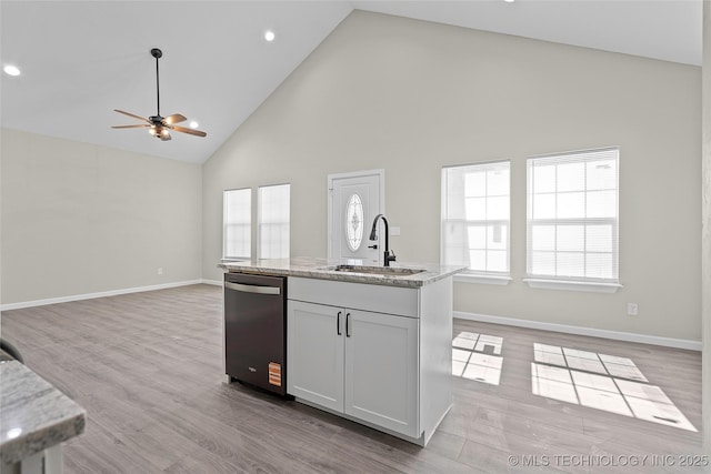 809 H NW, Ardmore, OK 73401 - kitchen featuring dishwashing machine, high vaulted ceiling, ceiling fan, open floor plan, and light wood-style flooring