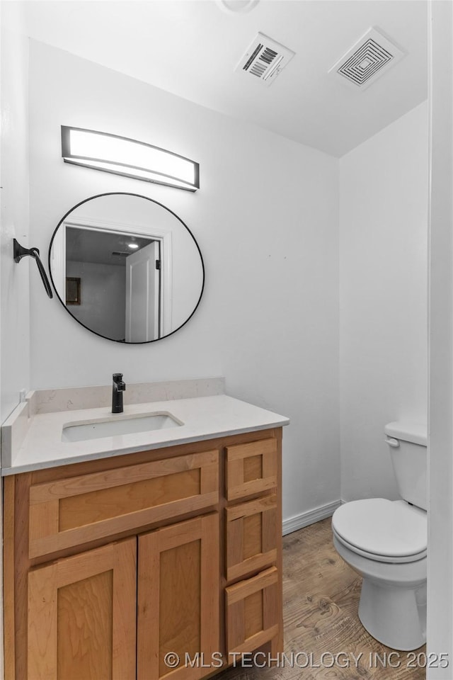 900 S Johnston, Ada, OK 74820 - half bath featuring toilet, vanity, wood finished floors, and baseboards