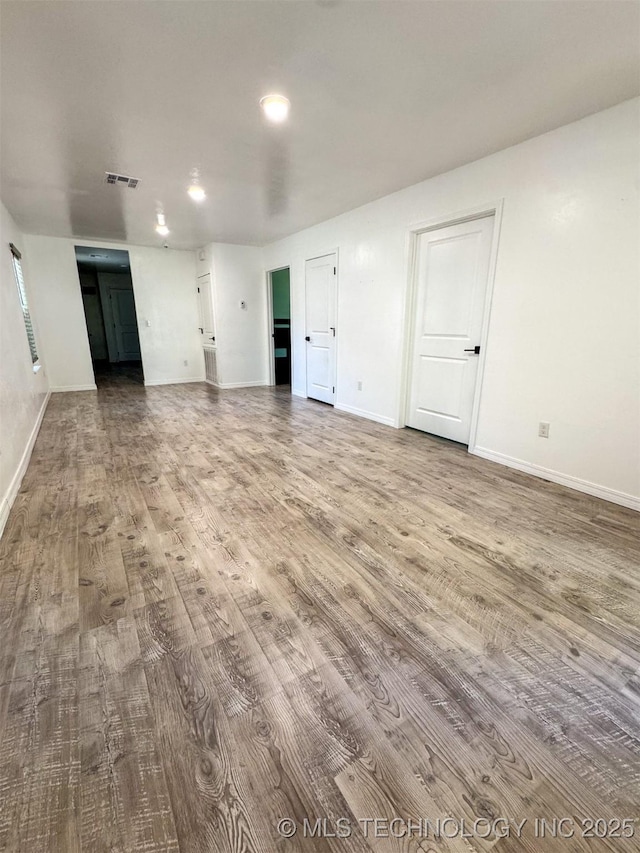 900 S Johnston, Ada, OK 74820 - unfurnished living room featuring wood finished floors, baseboards, and recessed lighting