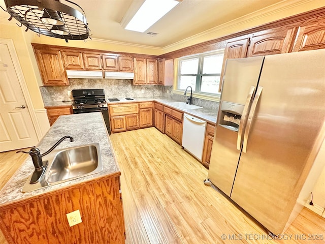 kitchen featuring light countertops, white appliances, light wood-type flooring, and a sink