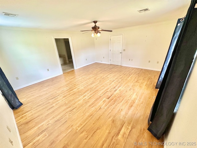spare room featuring ornamental molding, visible vents, a ceiling fan, and light wood-style floors
