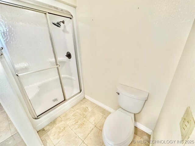 full bathroom with toilet, baseboards, a shower stall, and tile patterned flooring