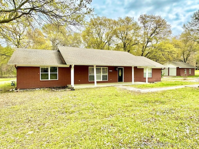 ranch-style home featuring roof with shingles, a front lawn, and brick siding