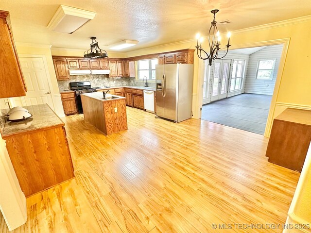 kitchen with crown molding, brown cabinets, appliances with stainless steel finishes, and a sink